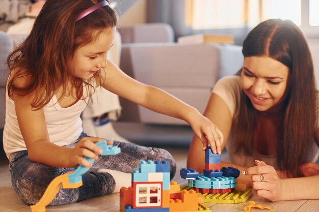 Photo caucasian young mother with her daughter is at home together