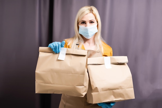 Caucasian young pretty woman, delivery worker medical mask. Female beautiful courier.