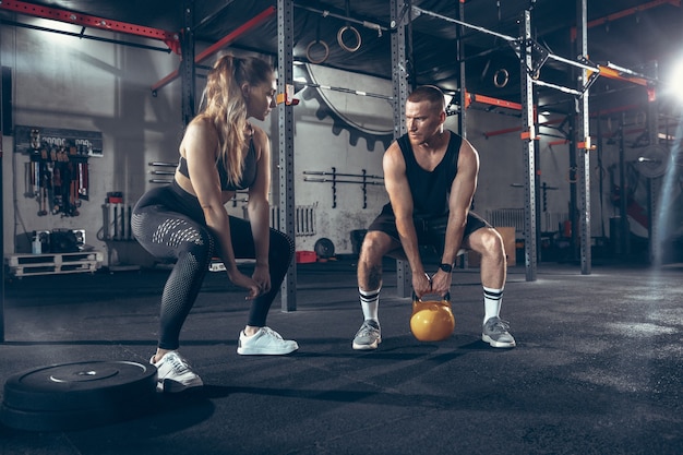 Caucasian young sporty couple workout in gym together.