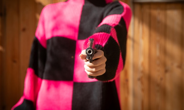 Photo caucasian young woman holding a pistol