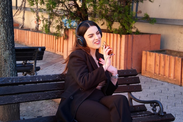 Caucasian young woman listening music on smartphone outdoor photo