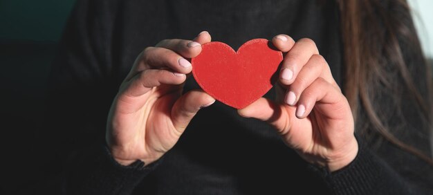 Caucasian young woman showing red heart