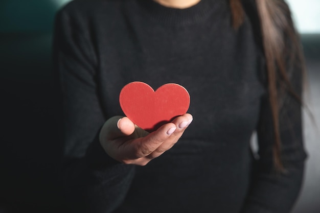 Caucasian young woman showing red heart