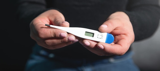 Caucasian young woman showing thermometer