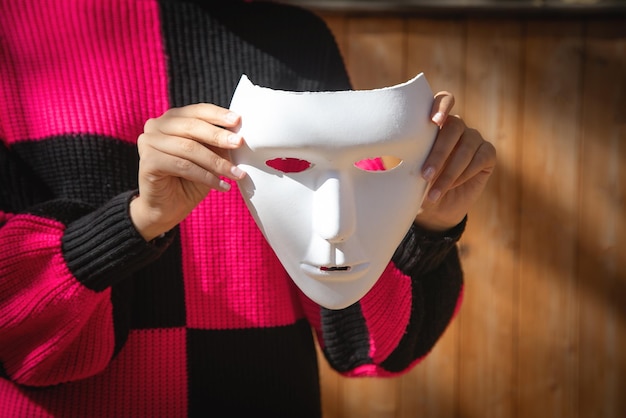 Caucasian young woman showing white face mask