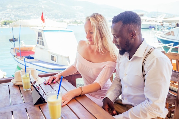 caucasian young woman with mixed-race african american male looking at smartphone route gps navigator at summer vacation in Turkey.