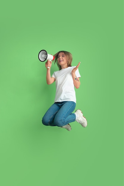 Caucasian young womans portrait on green studio wall