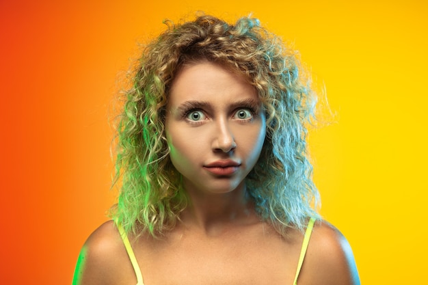 Caucasian young womans portrait isolated on gradient studio background in neon