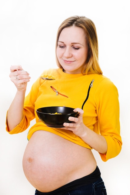 Caucassian pregnant woman with cornflakes isolated on white