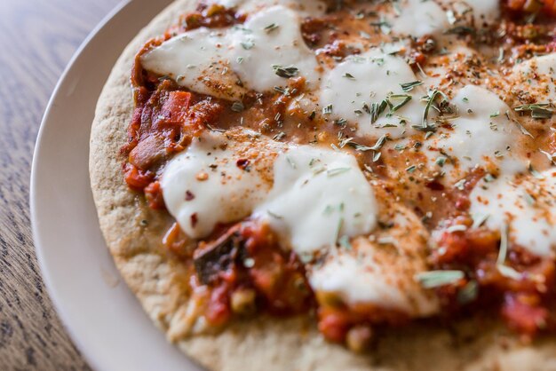 Foto pizza a pasta di cavolfiore, mozzarella di pomodoro e condimenti