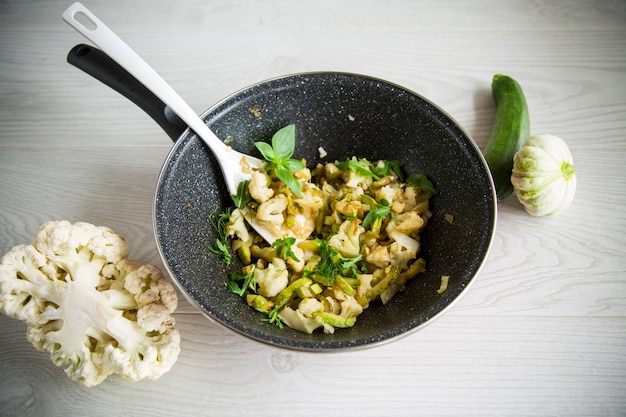 Cauliflower fried with zucchini and vegetables in a pan with herbs