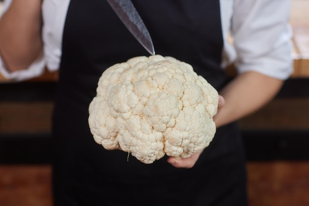 Cauliflower holding in female hands closeup man without face