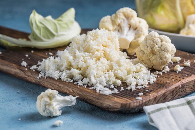 Cauliflower rice in a bowl on light stone background with free text space.