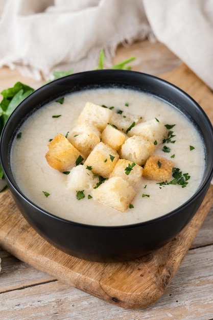 Cauliflower soup in a bowl on wooden table