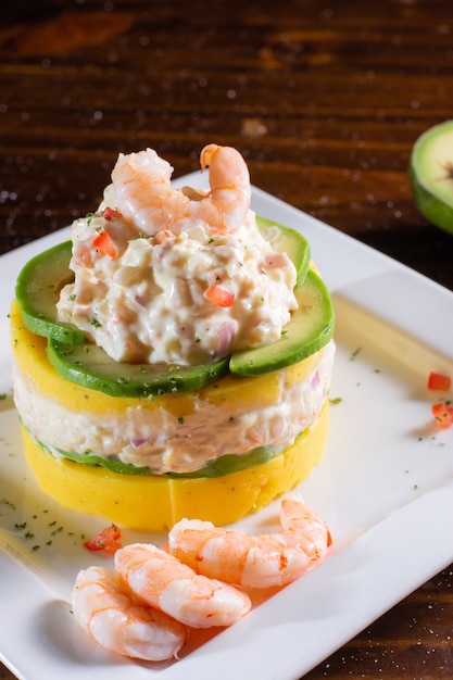 Causa whit seafood prawns typical peruvian food in wood table
