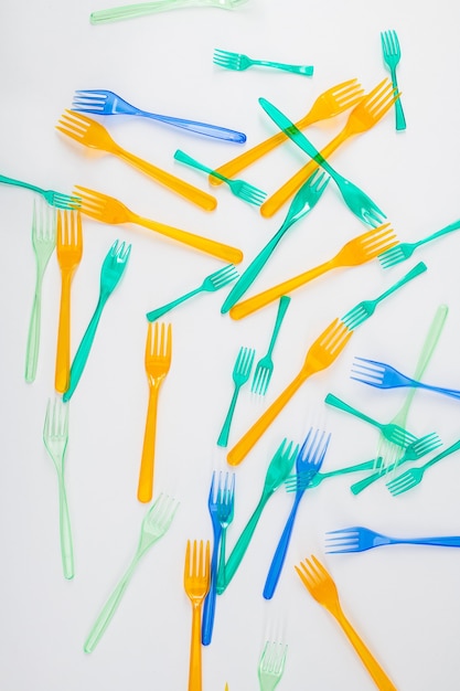 Causing global warming. Bright and colorful dangerous plastic forks affecting nature and being result of greenhouse gases