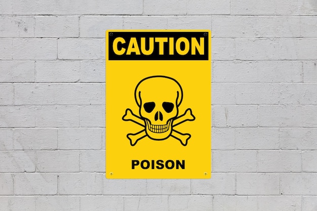 caution poison sign on a cinder block wall