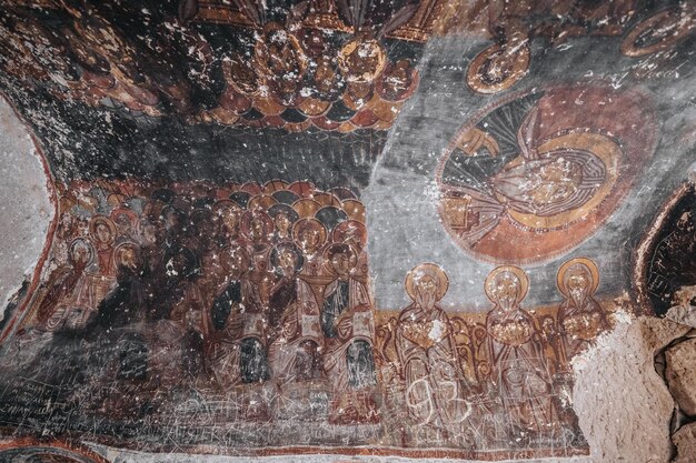 カッパドキアの洞窟教会で、キリスト教の始まりから壁のフレスコ画に碑文が刻まれています