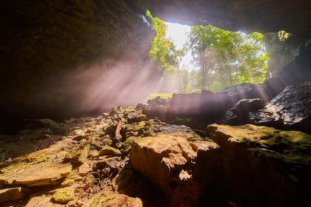 Cave opening with beams of light shining in