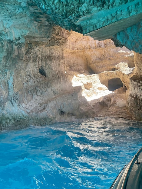 A cave with a boat in it and a boat in the water