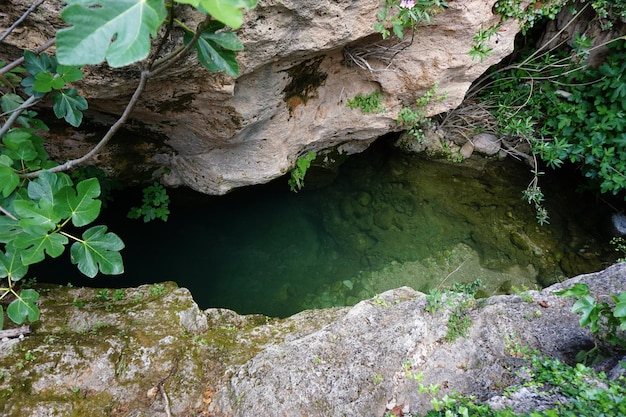 A cave with a pool of water in the middle