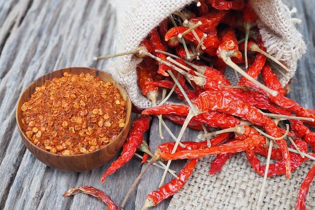 Cayenne pepper and dried red chili with sack on wooden table