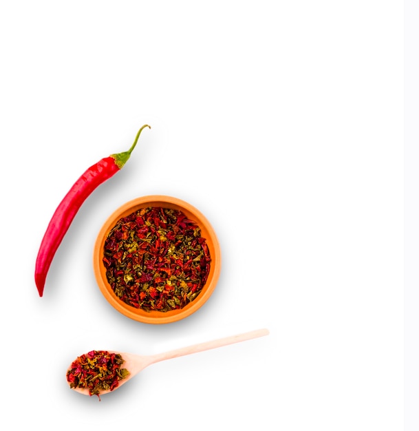 Cayenne pepper and Red peppers on plate and wooden spoon on white background.