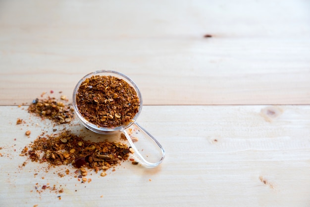 cayenne pepper spice in spoon on wooden table