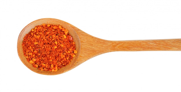 Cayenne pepper in wood spoon on white 