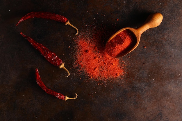 Cayenne pepper on wooden spoon spices and dried chilli peppers background
