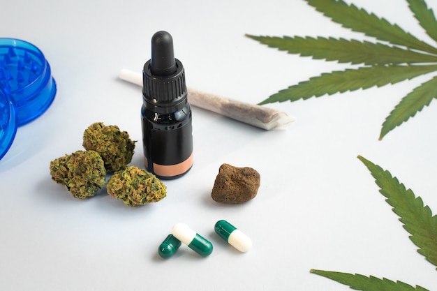 CBD oil capsules and hemp buds on white background Organic and natural hemp based cosmetic