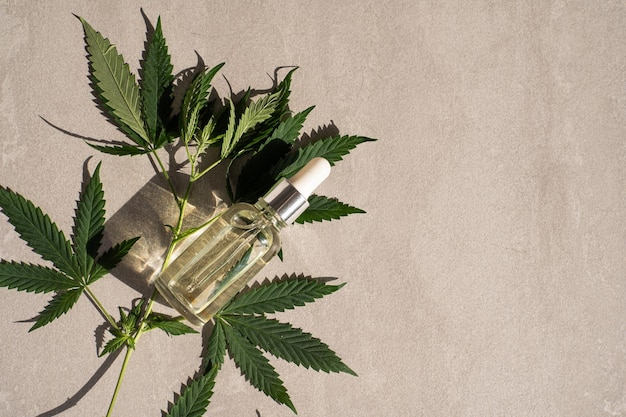 Foto prodotti a base di canapa oleosa bottiglia di vetro con olio di cbd foglie di canapa cannabis medicinale con estratti di olio cosmetici olio cbd