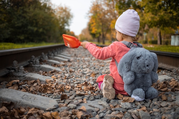 Ребенок играет на заброшенной железнодорожной линии в летний солнечный день