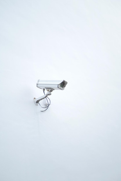 CCTV-beveiligingscamera op een witte muur met kopieerruimte