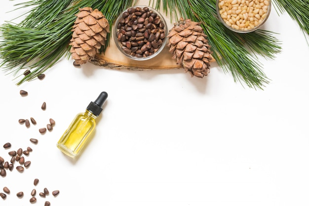 Photo cedar oil, branches and cedar cone on white. copy space. beauty and healthy concept.