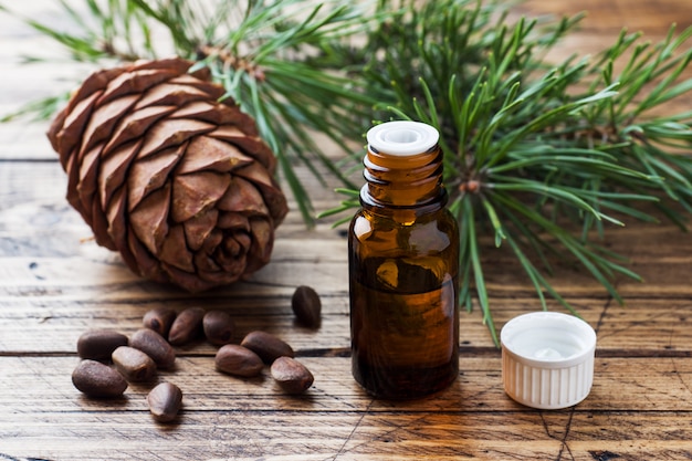 Cedar and spruce essential oil in small glass bottles on wooden table. 