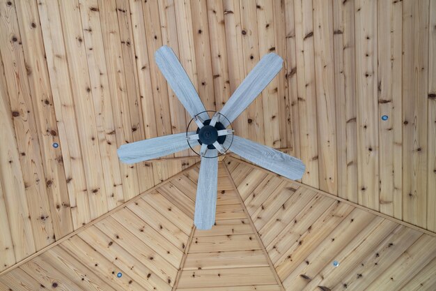 Photo ceiling fan with wooden blades has been installed overhead