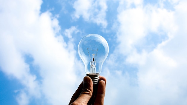 Ceiling lamp in hand on blue sky background