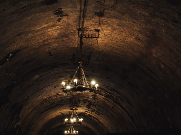 古いワイナリーの暗いトンネルにある天井とヴィンテージのシャンデリア