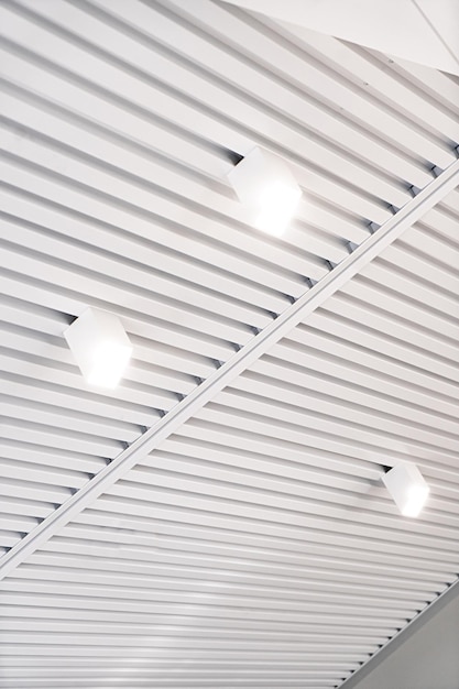 Ceiling with bright lights in a modern warehouse shopping center building office or other commercial real estate object Directional LED lights on rails under the ceiling