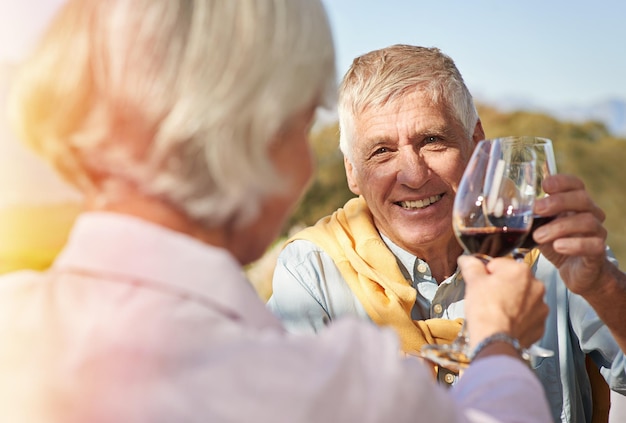 Празднуйте жизнь Снимок счастливой пожилой пары, поднимающей бокалы вина