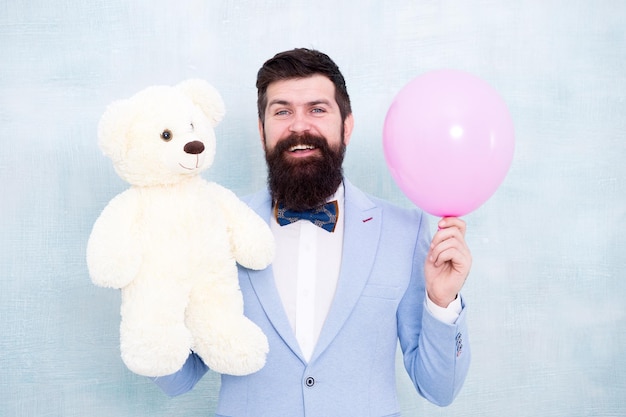 Celebrate love Valentines day Romantic man with teddy bear and air balloon waiting girlfriend Romantic gift Macho ready romantic date Man wear tuxedo bow tie Womens day Greetings 8 march