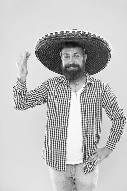 Celebrate traditional mexican holiday Lets have fun Mexican guy happy festive outfit ready to celebrate Man bearded cheerful guy wear sombrero mexican hat yellow background Mexican party concept