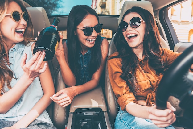 Celebrating a great day. Three beautiful young cheerful women looking at each other with smile 