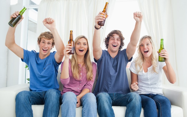 A celebrating group as they look at the camera with beer in their hands