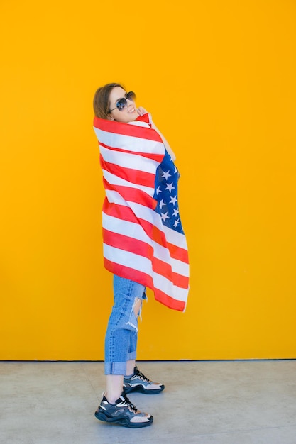 Celebrating an independence day stars and stripes young woman\
with the flag of the united states