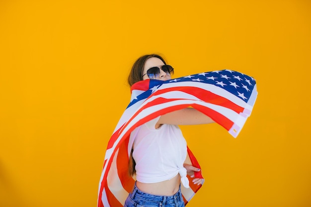 Celebrating an independence day stars and stripes young woman\
with the flag of the united states