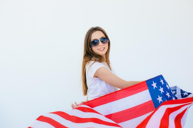 Celebrating an independence day stars and stripes young woman\
with the flag of the united states