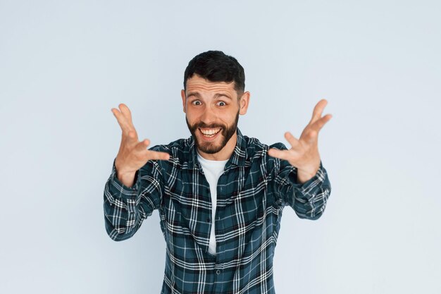 Celebrating success Young man in casual clothes standing indoors in the studio