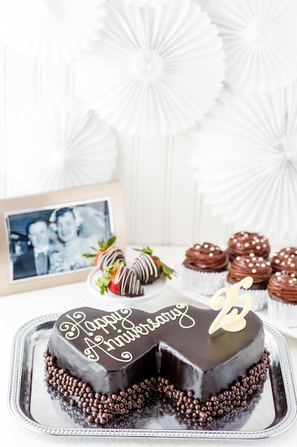 Celebrating wedding anniversary with heart shape chocolate cake.